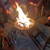People sitting around a fire pit on a stone pavement