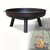 Black metal fire pit with a steaks grilling on a stand over flames