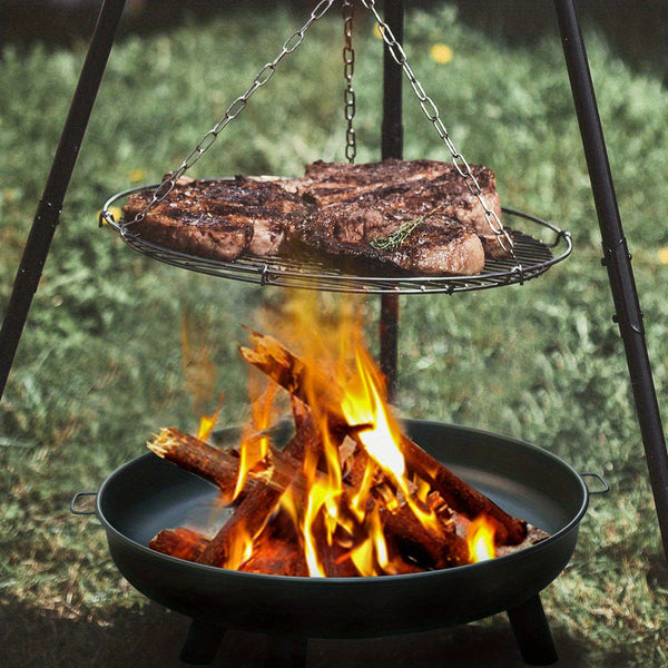 Grill over an open fire with steaks cooking above.