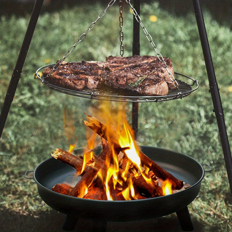 Grill over an open fire with steaks cooking above.