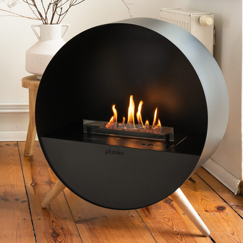Modern freestanding fireplace with flames on a wooden floor