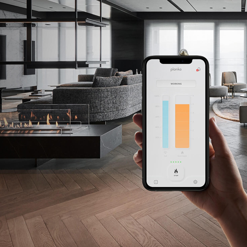 Hand holding a smartphone with a home automation app in a modern living room.