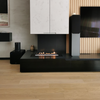 Modern living room with a black fireplace, speakers, and a television.