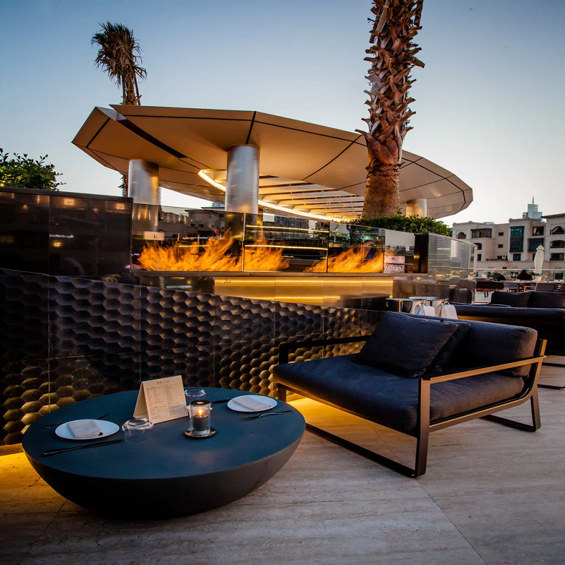 Fire burning at a restaurant poolside in the Galio Gas Fire Pit Insert Linear Automatic