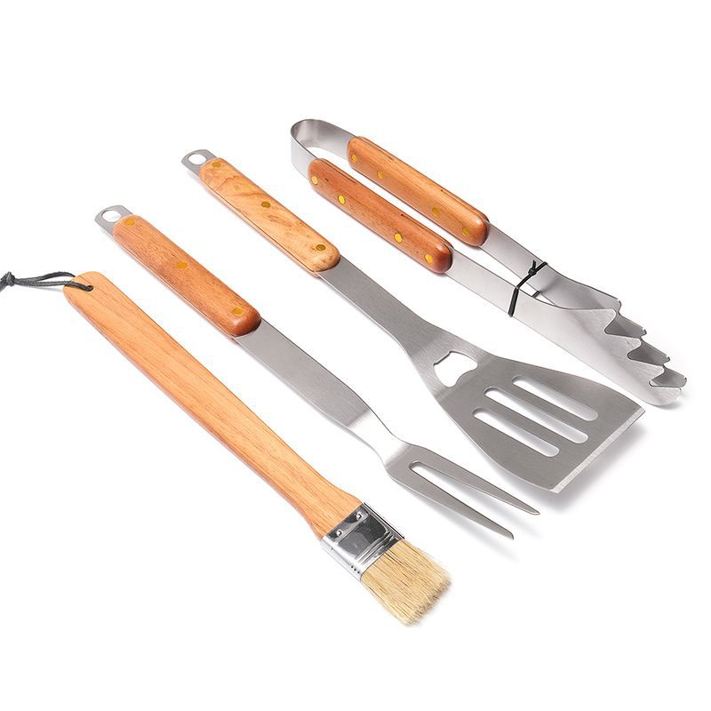 Set of four barbecue tools with wooden handles on a white background