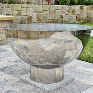 The Goblet Stainless Steel Fire Pit and stainless steel lid in an outdoor space