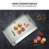Grill pan with food items on a dark surface, highlighting even heat distribution.