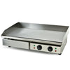 Stainless steel griddle with control knobs on a white background