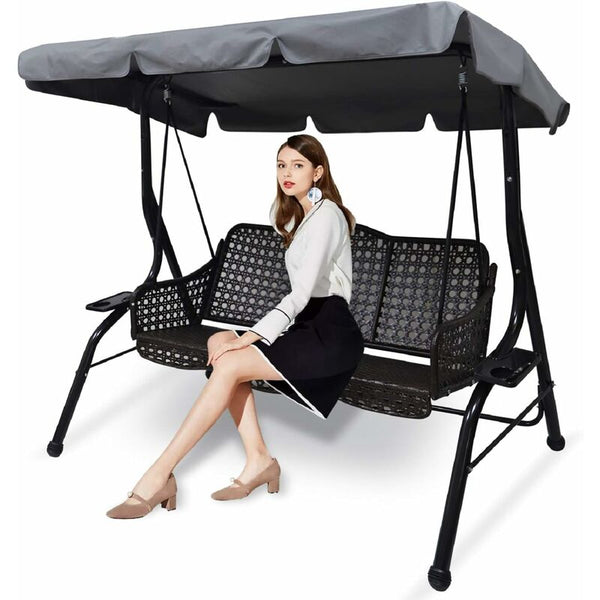 Woman sitting on a black outdoor swing with canopy on a white background