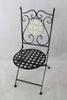 Black metal chair with decorative backrest on a light gray background