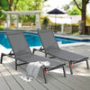 Two gray lounge chairs on a wooden deck by a pool with a towel draped over one of them.