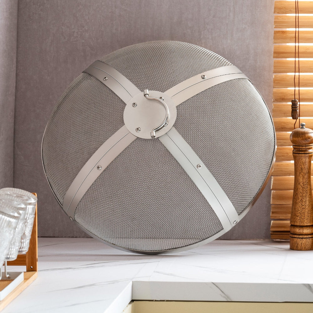 Round metallic fire screen on a white surface with a neutral background