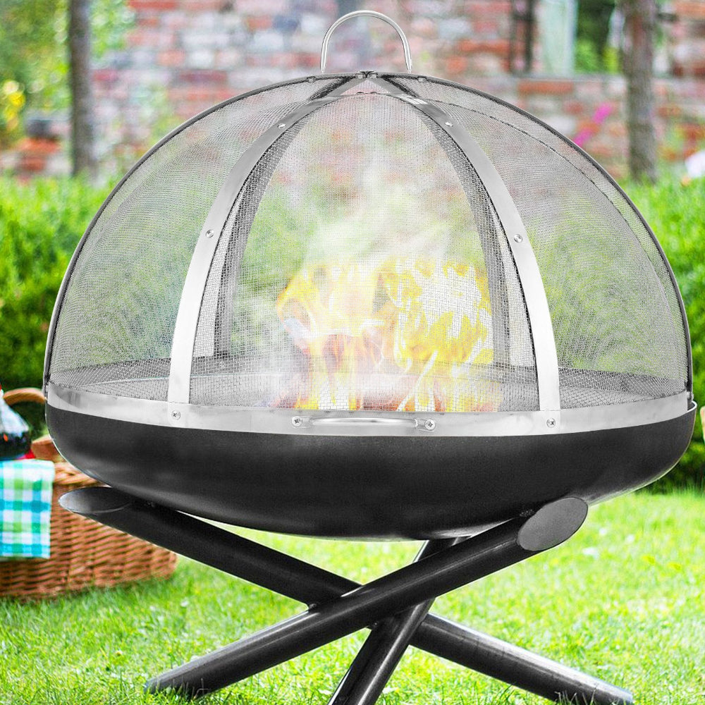Outdoor fire pit with mesh cover on a grassy area