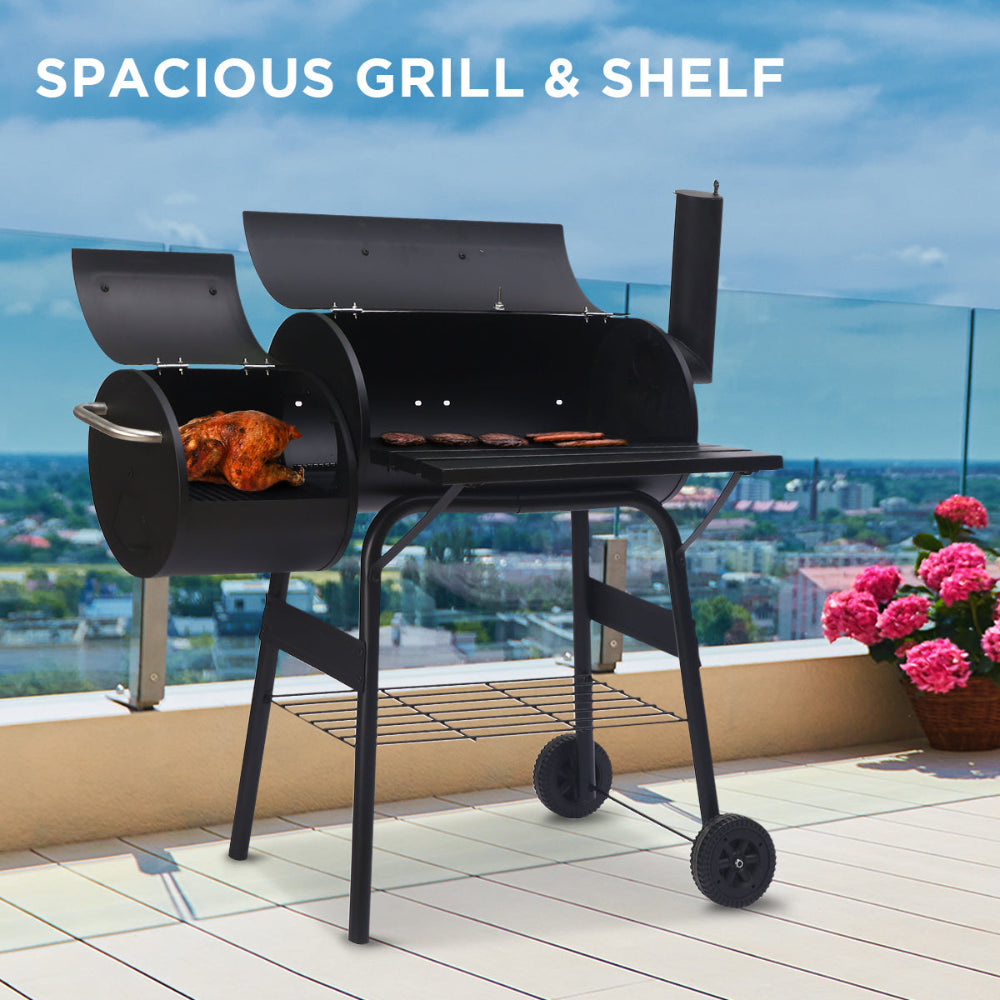 Black grill with a spacious shelf on a balcony with a cityscape view