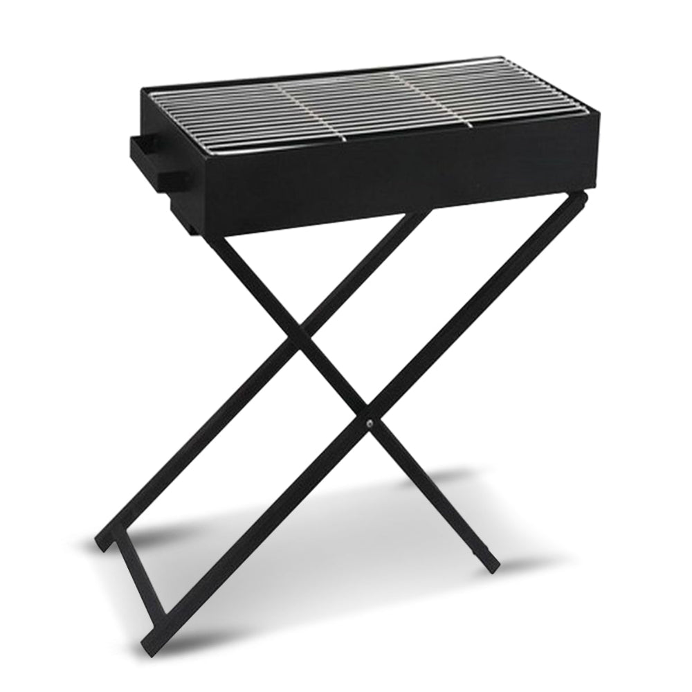 Portable charcoal grill with foldable legs on a stand set on a solid white background.