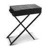 Portable charcoal grill with foldable legs on a stand set on a solid white background.