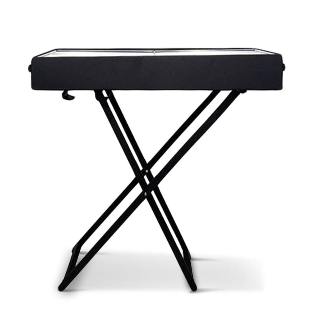 Side view of a portable charcoal grill with foldable legs on a stand set on a solid white background.