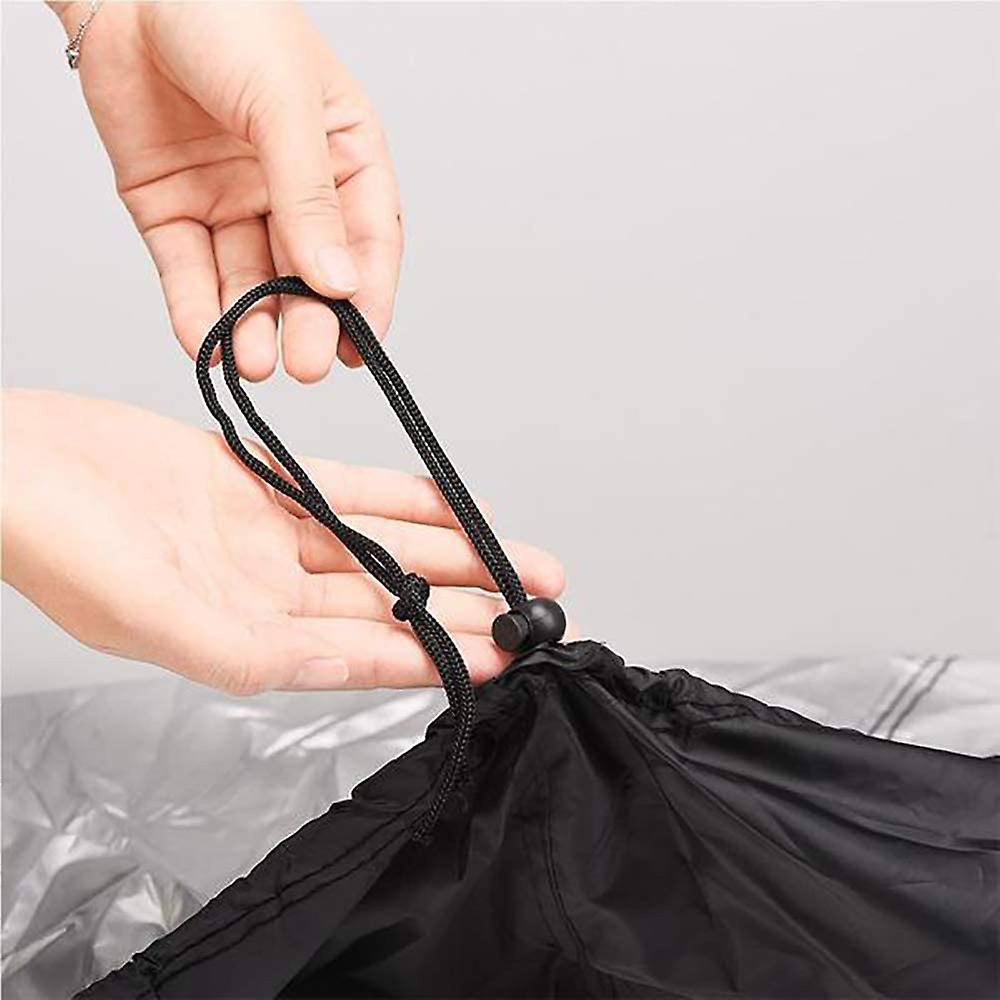 Person holding a black drawstring on a black bag against a gray background
