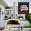 Outdoor pizza oven with a built-in thermometer displaying temperature, set against a house and garden background.