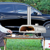 Portable pizza oven being used outdoors with a car in the background