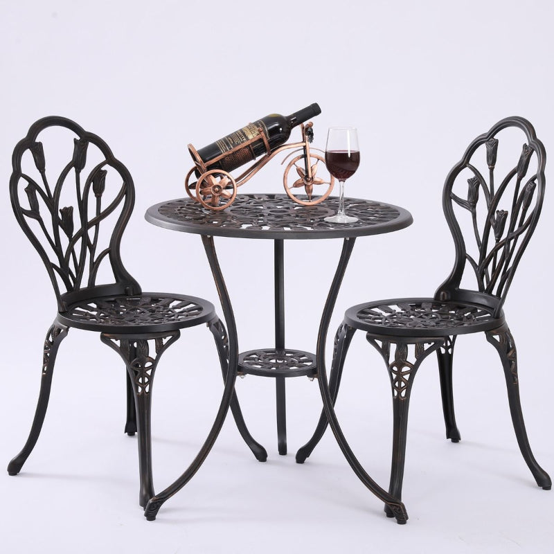 Dominique bronze coloured 3 Piece setting with bottle of red wine on an ornamental tricycle and a glass of red win on the table, with a white background.