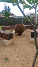 Load image into Gallery viewer, The Lotus Fire Pit in a nice back yard setting