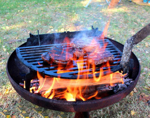 Yagoona Yabbi Fire Pit and Barramundi wood BBQ with steaks cooking