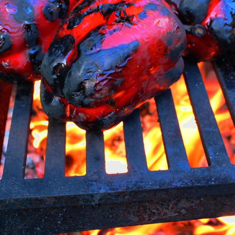 Yagoona Barramundi wood BBQ grill charring red capsicums over flames.