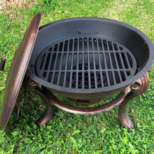 Load image into Gallery viewer, Top view of Vesuvius Firepit BBQ with Lid and grilling rack on a lawn