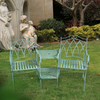 Sage coloured Companion 3 Piece Outdoor Setting Australia in garden setting on grass with bushes, tree and large cement statues in the background.