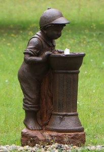 Boy at Water Fountain with water bubbling in a garden setting