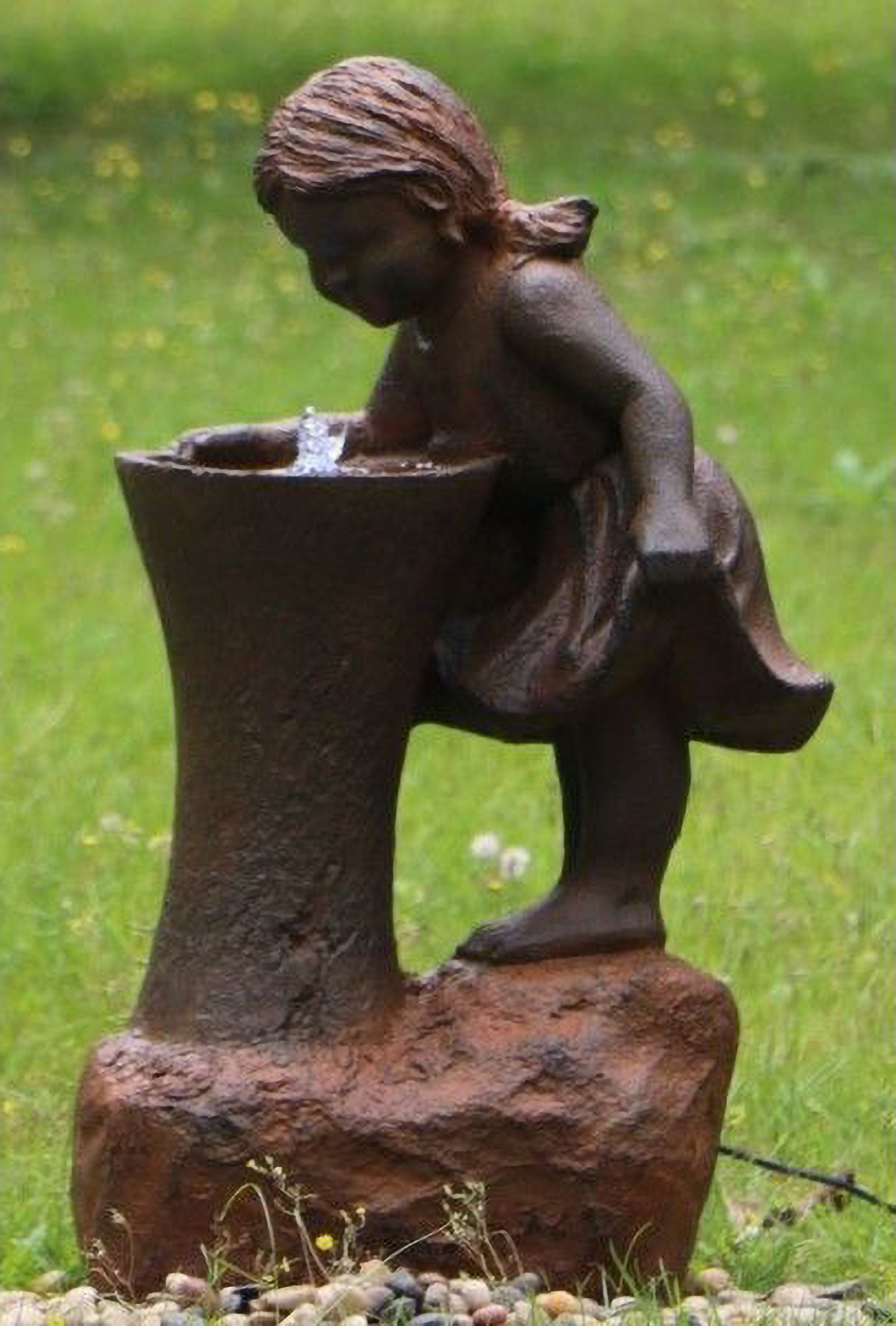 Girl at Water Fountain with water bubbling in a garden setting