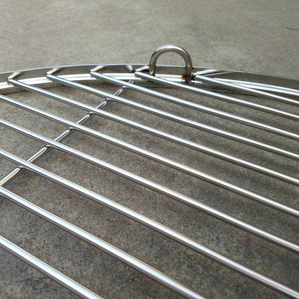 Close up of a side of a Stainless Steel BBQ Cooking Grill on a cement floor