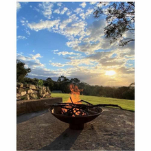 Load image into Gallery viewer, The Cauldron Fire Pit 1500mm burning a fire with sunset in background