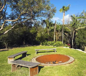 The Cauldron Fire Pit 1500mm sunk into the ground with wooden benches around it