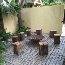 Load image into Gallery viewer, Cauldron Fire Pit in an outdoor area with log seats around it