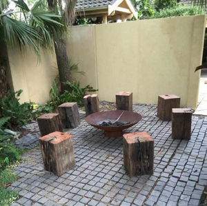Cauldron Fire Pit in an outdoor area with log seats around it