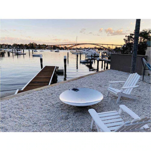 The Cauldron 100cm Stainless Steel Fire Pit beside the ocean