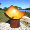 The Chalice Fire Pit at the seaside in a rusted finish