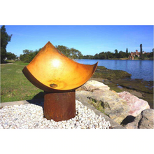 Load image into Gallery viewer, The Chalice Fire Pit at the seaside in a rusted finish