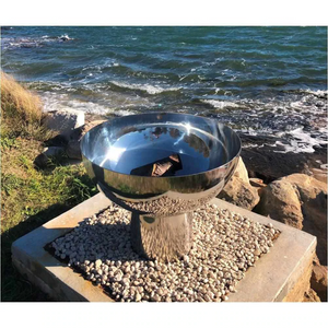 The Goblet Stainless Steel Fire Pit at the seaside on a 30cm high stand