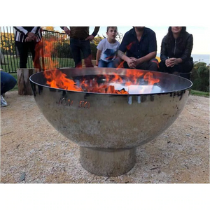 The Goblet Stainless Steel Fire Pit on the 15m stand with fire burning and people sitting around