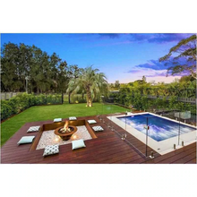 Load image into Gallery viewer, The Teppanyaki Fire Pit in backyard beside a pool with fire burning