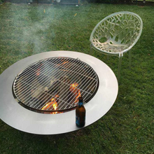 Load image into Gallery viewer, Teppanyaki Stainless Steel Fire Pit in backyard setting with fire burning