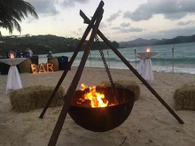 Load image into Gallery viewer, The Tripod Fire Pit on a beach at a party setting