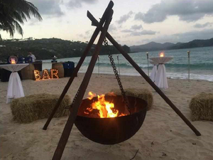 The Tripod Fire Pit on a beach at a party setting