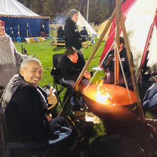 Load image into Gallery viewer, The Tripod Fire Pit at a campsite with people gathering