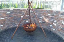 Load image into Gallery viewer, The Tripod Fire Pit set up in an outdoor fire pit space 