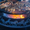 Close up photo of the stockman design Ultimate BBQ Fire Pit with meat cooking on the top of the flames.