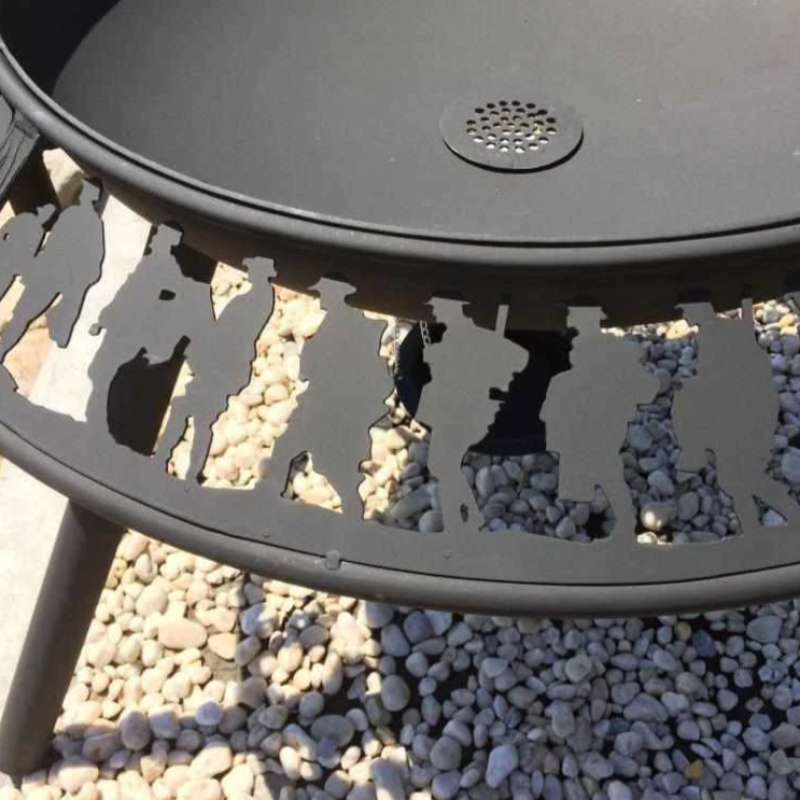 Close up of soldiers on the Anzac pattern on the Ultimate BBQ Fire Pit with gravel stones beneath it.